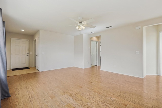 unfurnished room with light wood-type flooring and ceiling fan