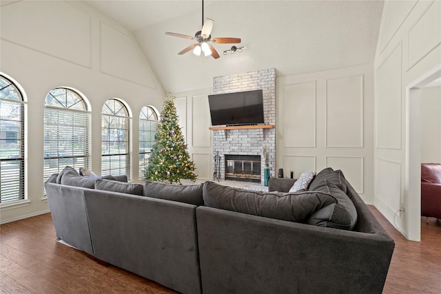 living room with dark hardwood / wood-style flooring, a brick fireplace, ceiling fan, and vaulted ceiling