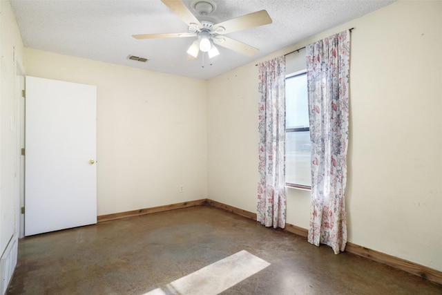 unfurnished room featuring ceiling fan, concrete flooring, and a textured ceiling