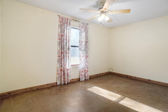 spare room featuring ceiling fan, concrete flooring, and a textured ceiling