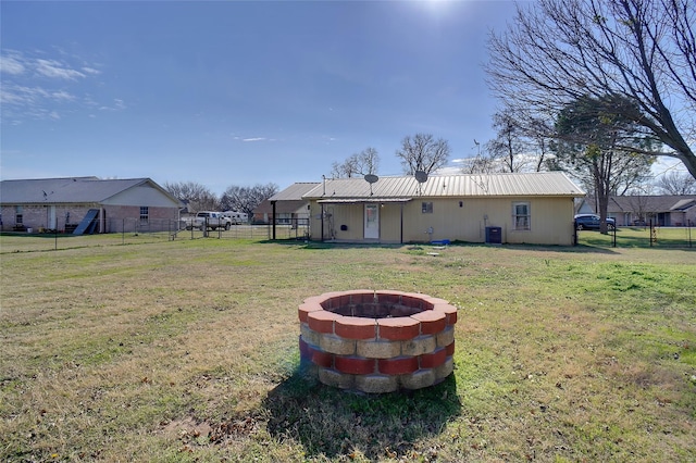 back of house featuring a fire pit, cooling unit, and a yard