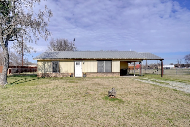 view of front of property with metal roof, fence, a front lawn, and brick siding