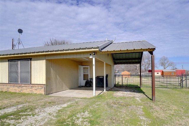 rear view of property with a lawn and a carport