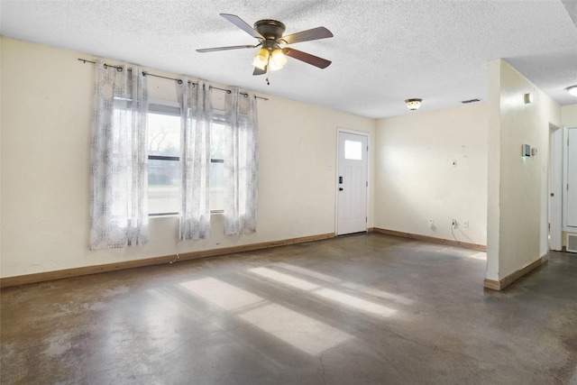 spare room with ceiling fan, concrete flooring, and a textured ceiling