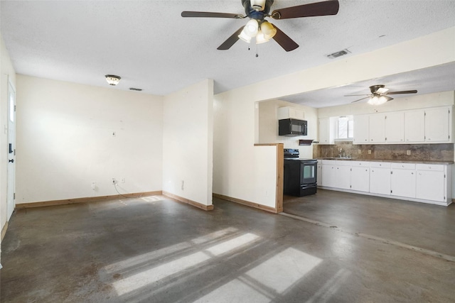 unfurnished living room with a textured ceiling, ceiling fan, and sink