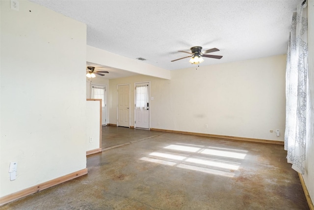 empty room featuring ceiling fan, a textured ceiling, and concrete floors