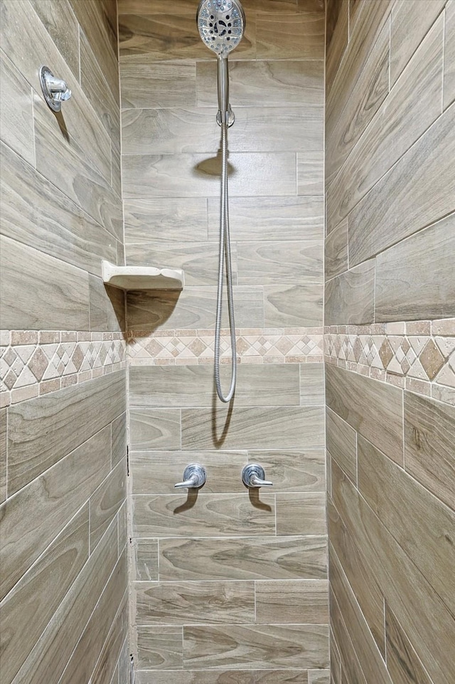 interior details featuring a tile shower