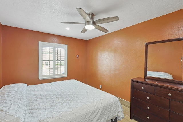 bedroom featuring a textured ceiling, light hardwood / wood-style floors, and ceiling fan