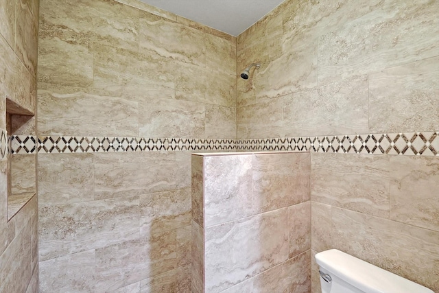 bathroom with tiled shower and toilet