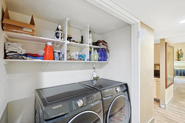 washroom with washing machine and dryer and light hardwood / wood-style flooring