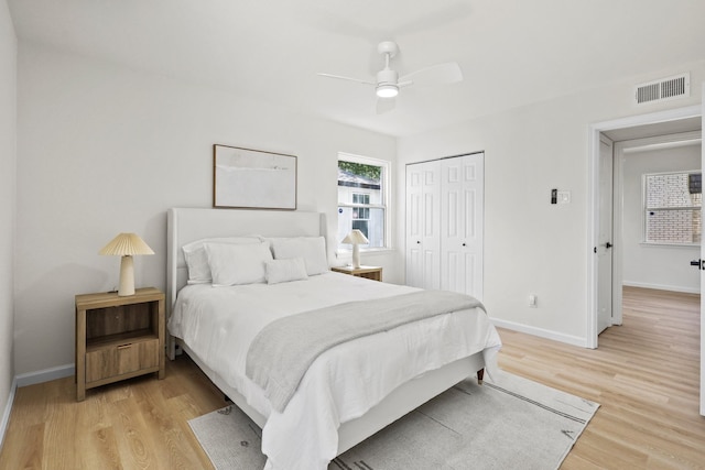 bedroom with light wood-type flooring, a closet, and ceiling fan