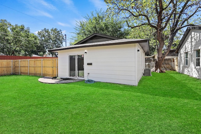 back of house featuring a yard and central air condition unit