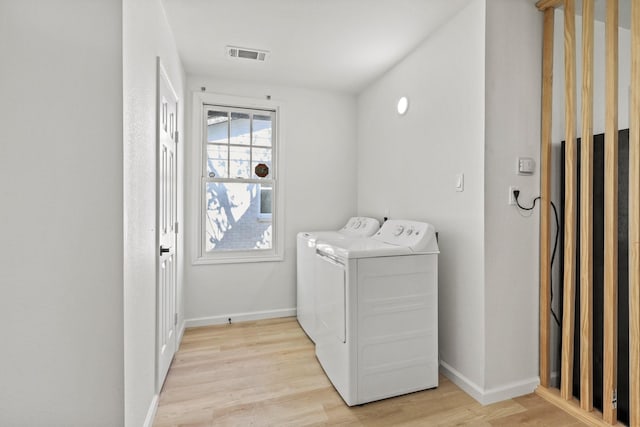 washroom with light hardwood / wood-style floors and separate washer and dryer