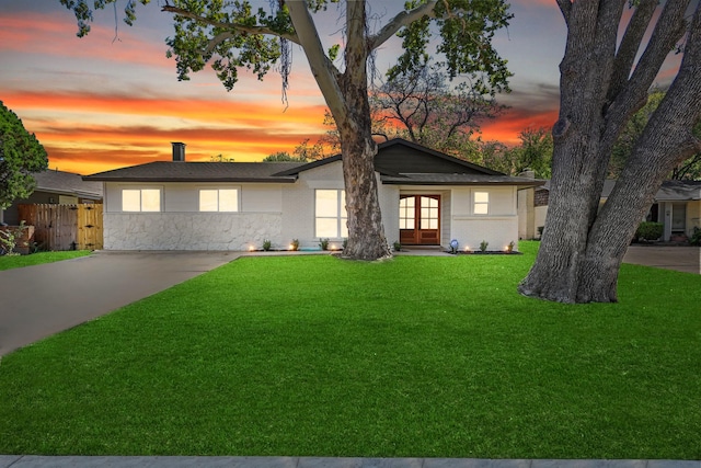 view of front facade featuring french doors and a yard