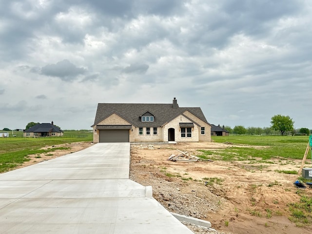 view of front of property featuring a chimney, brick siding, a garage, and concrete driveway