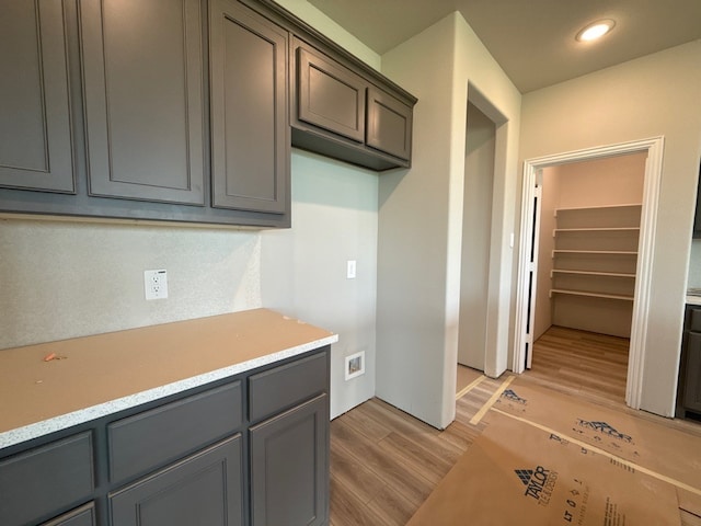 kitchen featuring light wood-style floors, gray cabinetry, light countertops, and recessed lighting