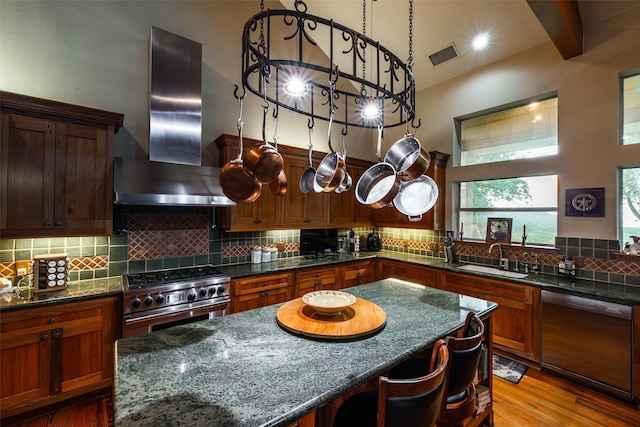 1665 W Belt Line Rd, Cedar Hill, TX 75104 - kitchen with stainless steel appliances, wall chimney range hood, a sink, a center island, and tasteful backsplash