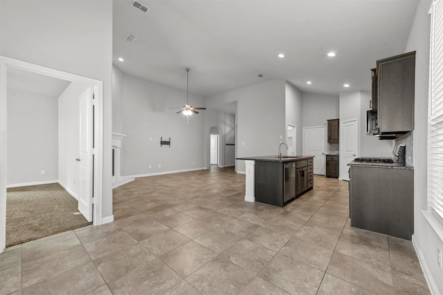 kitchen with ceiling fan, a center island with sink, dark brown cabinets, and sink