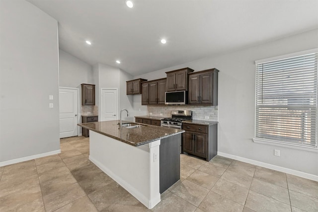 kitchen featuring a center island with sink, decorative backsplash, sink, and stainless steel appliances