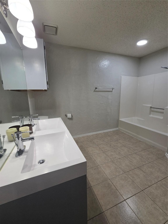 bathroom featuring tile patterned flooring, vanity, a textured ceiling, and tub / shower combination