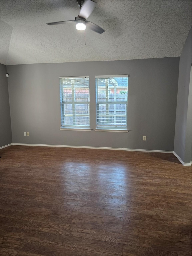 spare room with vaulted ceiling, ceiling fan, dark hardwood / wood-style floors, and a textured ceiling