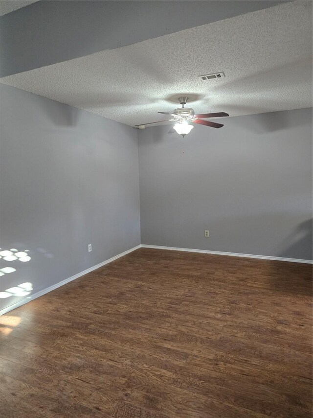 unfurnished room with dark hardwood / wood-style flooring, lofted ceiling, and a textured ceiling