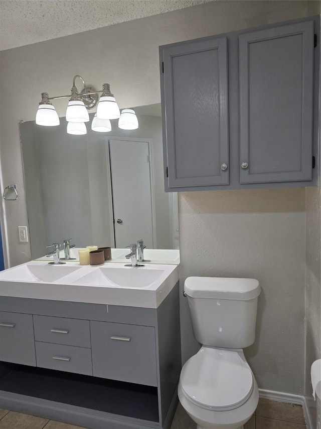 bathroom with tile patterned flooring, vanity, a textured ceiling, and toilet