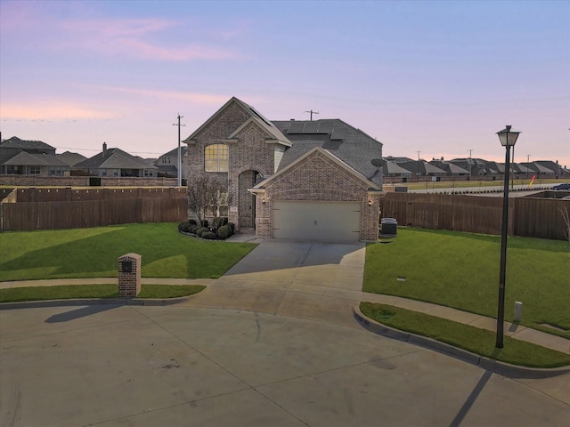 view of front of property with a yard and a garage