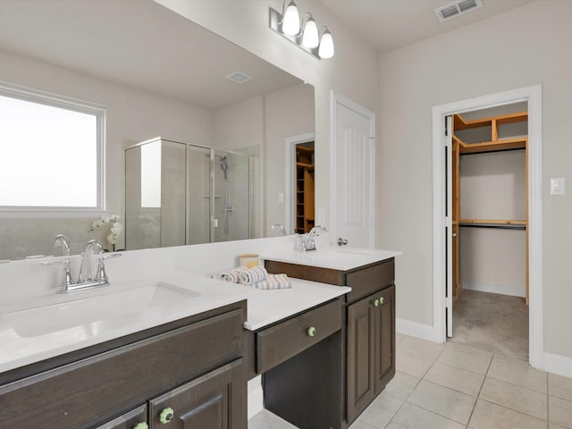 bathroom featuring a shower with shower door, vanity, and tile patterned flooring