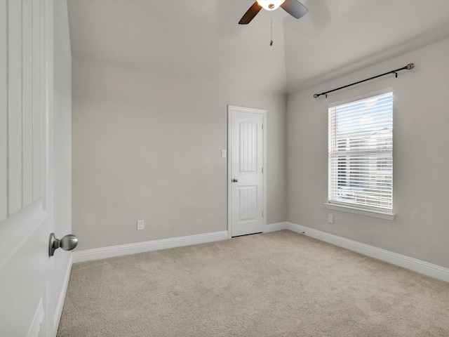 carpeted spare room featuring ceiling fan and lofted ceiling