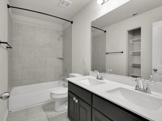 full bathroom featuring toilet, tiled shower / bath, tile patterned floors, and vanity