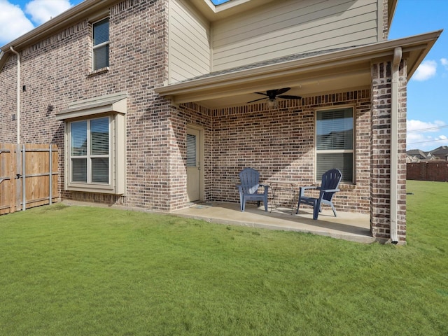 rear view of house with ceiling fan, a yard, and a patio