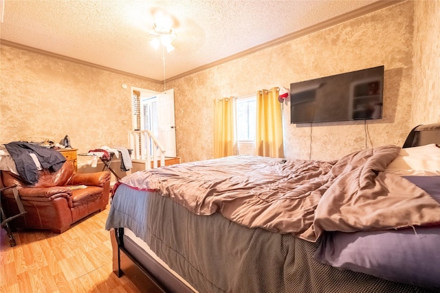 bedroom with ceiling fan, ornamental molding, a textured ceiling, and hardwood / wood-style flooring