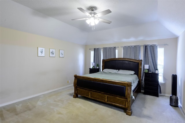 bedroom with ceiling fan, lofted ceiling, and light carpet