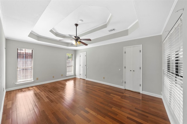 interior space featuring a raised ceiling, ceiling fan, dark hardwood / wood-style flooring, and ornamental molding