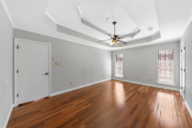 unfurnished room featuring dark hardwood / wood-style flooring, ceiling fan, a raised ceiling, and crown molding