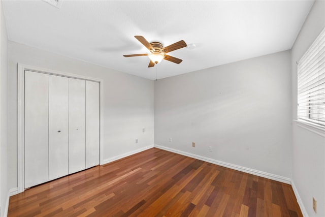 unfurnished bedroom featuring a closet, hardwood / wood-style flooring, and ceiling fan