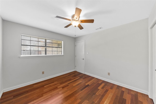 unfurnished room with ceiling fan and dark hardwood / wood-style flooring