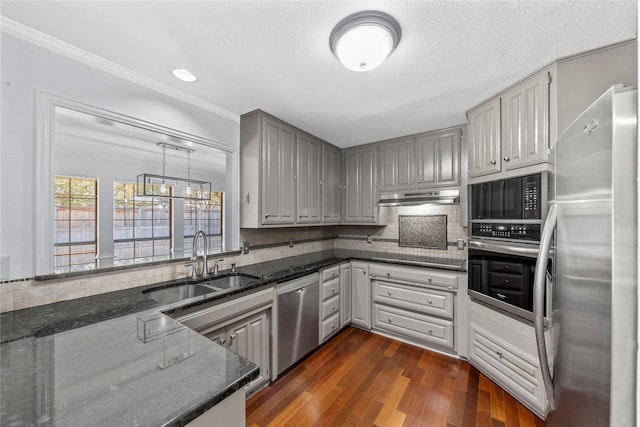 kitchen featuring appliances with stainless steel finishes, dark hardwood / wood-style flooring, sink, dark stone countertops, and gray cabinets