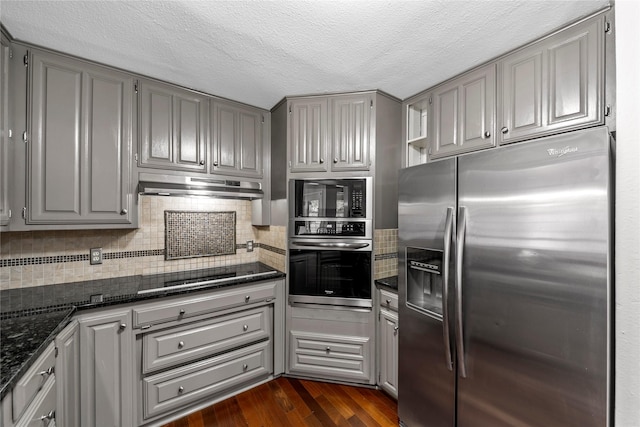 kitchen featuring gray cabinetry, dark stone countertops, and black appliances