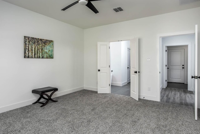 unfurnished bedroom with dark colored carpet and ceiling fan