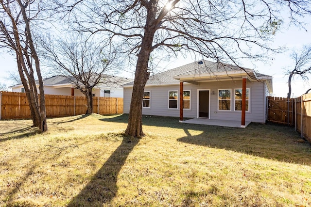 rear view of property with a patio and a lawn