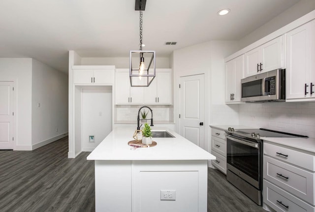 kitchen featuring sink, hanging light fixtures, an island with sink, white cabinetry, and stainless steel appliances