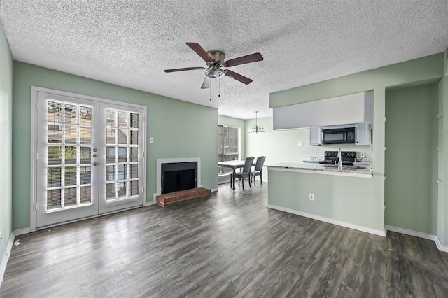 kitchen featuring black appliances, a brick fireplace, ceiling fan, decorative light fixtures, and white cabinetry