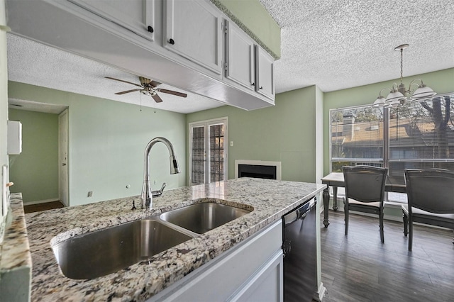 kitchen with ceiling fan with notable chandelier, sink, pendant lighting, white cabinets, and black dishwasher