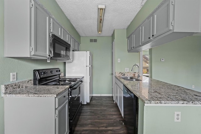 kitchen featuring light stone countertops, kitchen peninsula, a textured ceiling, sink, and black appliances