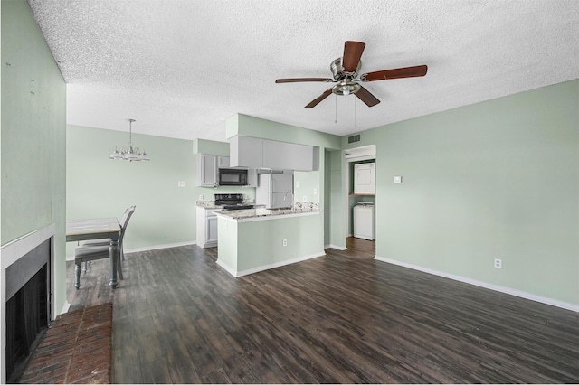 kitchen featuring a brick fireplace, dark wood-type flooring, black appliances, pendant lighting, and gray cabinets