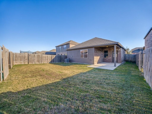 rear view of house with a patio, central AC unit, and a lawn