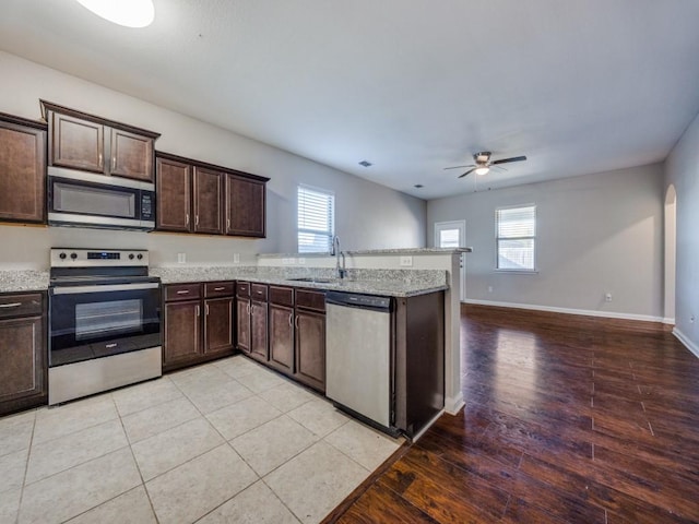 kitchen with dark brown cabinets, stainless steel appliances, a wealth of natural light, and sink