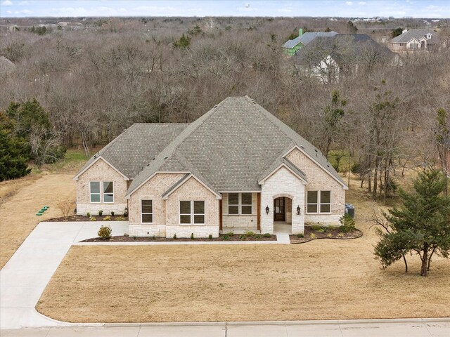 french provincial home with a front lawn